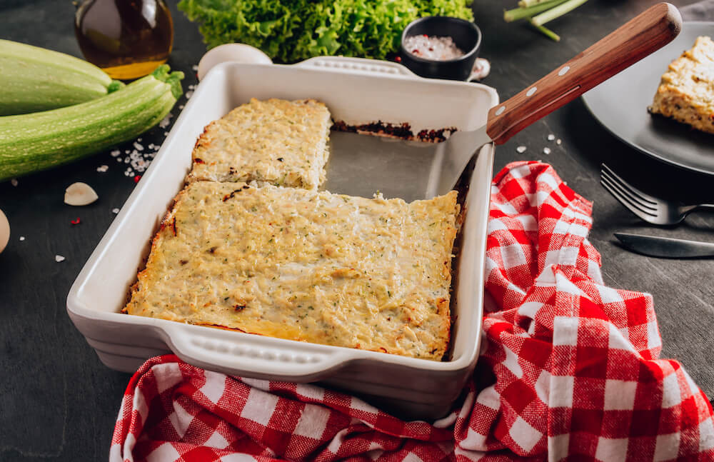 Zucchini casserole on dark background. Dietary, low-calorie, healthy food. Homemade Casserole from squash with chicken and eggs.